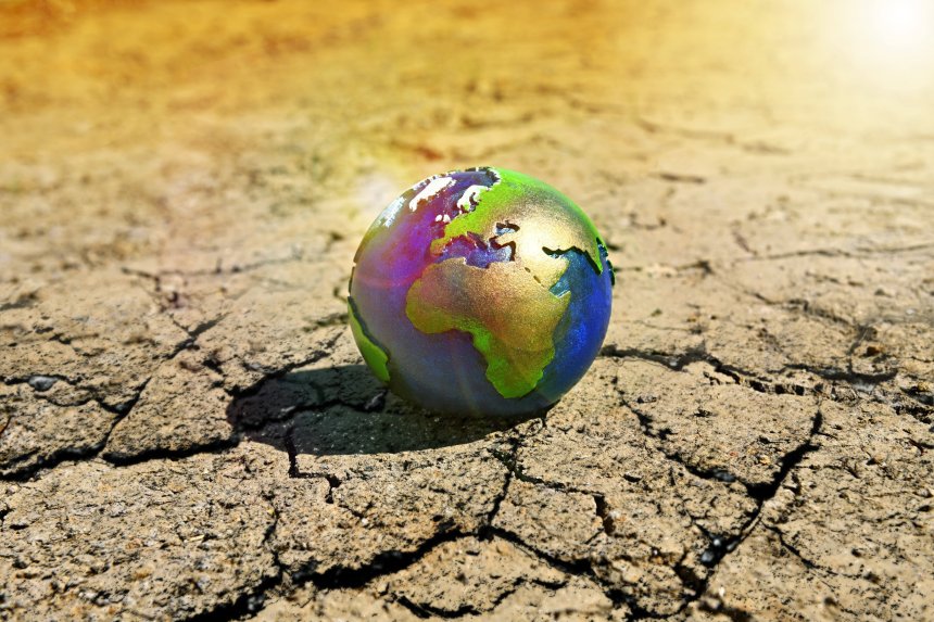 HOTOMONTAGE, Earth globe on dry ground, sym